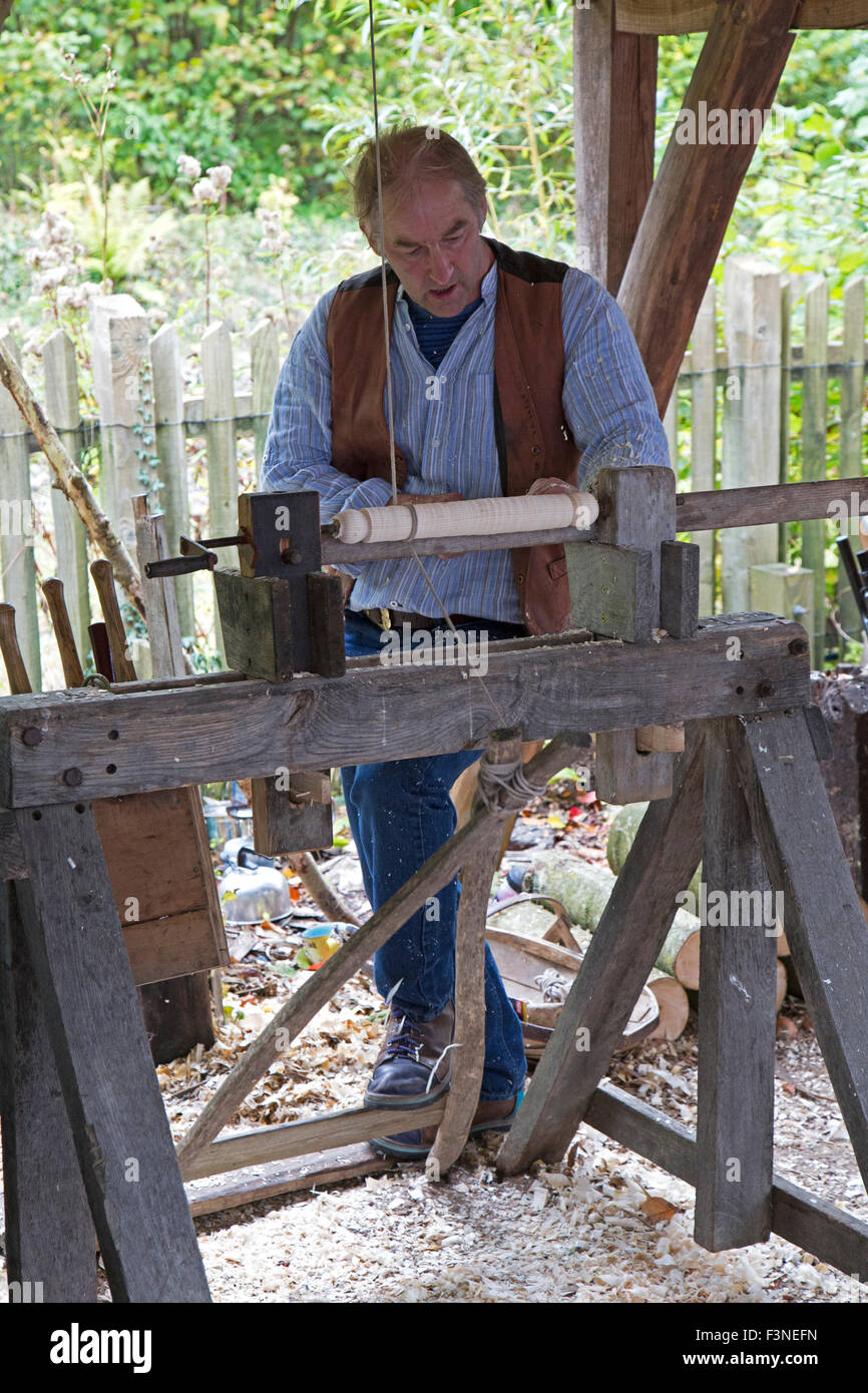 Ein Mann mit einem traditionellen Fuß angetrieben Holz Drehbank Drehmaschine. Stockfoto