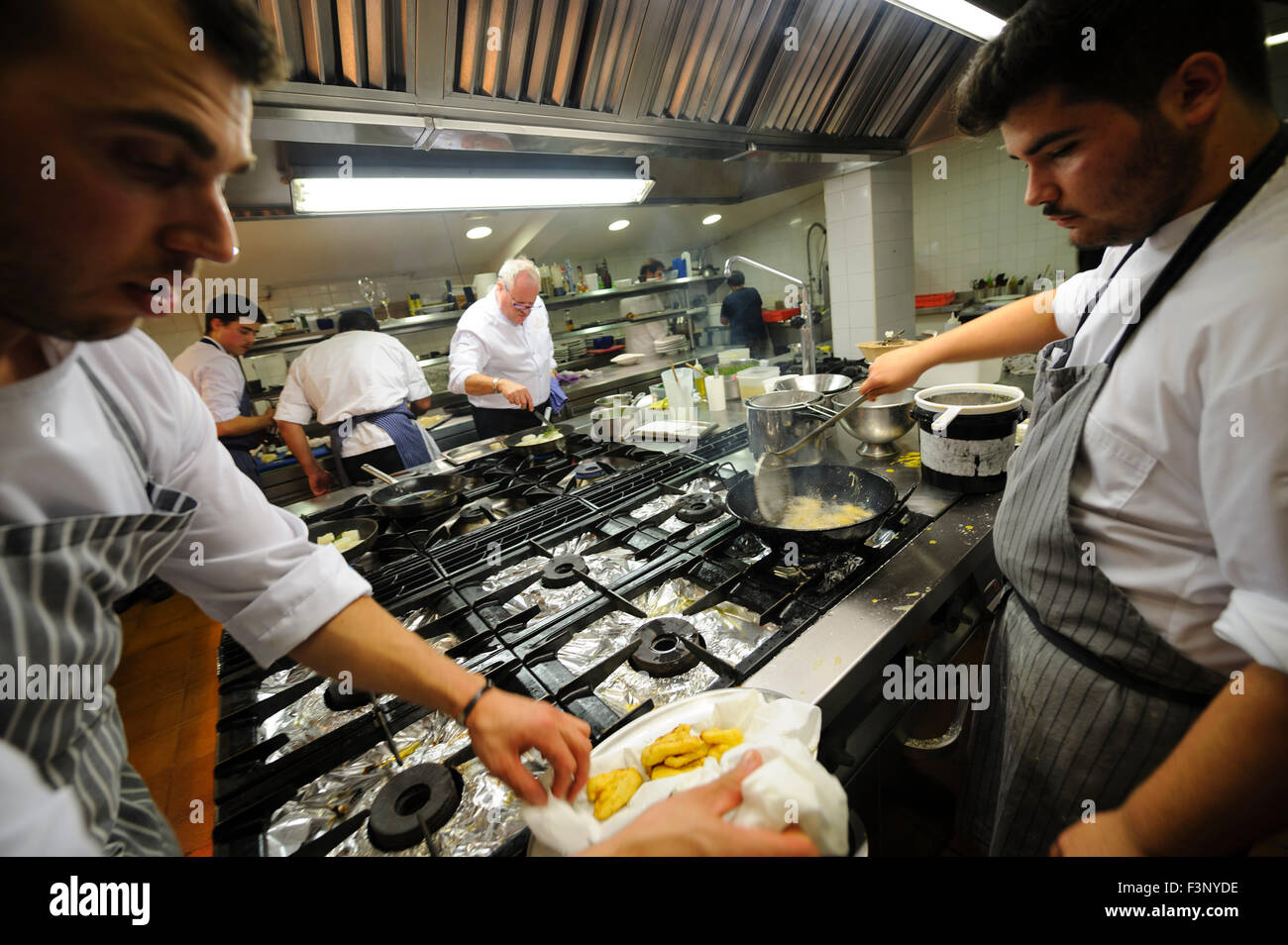 Köche Braten Fisch auf einer professionellen Restaurantküche Stockfoto