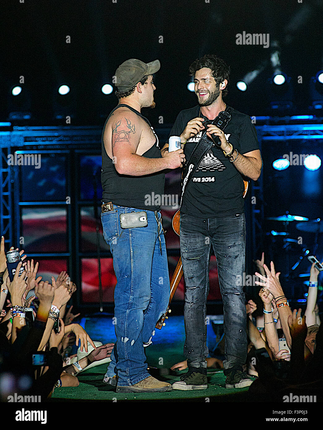 Manhattan, Kansas 25.06.2015 Country-Music-Star Thomas Rhett umfasst dessen Schließung heute Abend am ersten Tag der "Kicker Land Stampede" in Manhattan, Kansas. Er zog ein Fan aus der Menge auf der Bühne mit ihm ein Duett zu tun. Stockfoto
