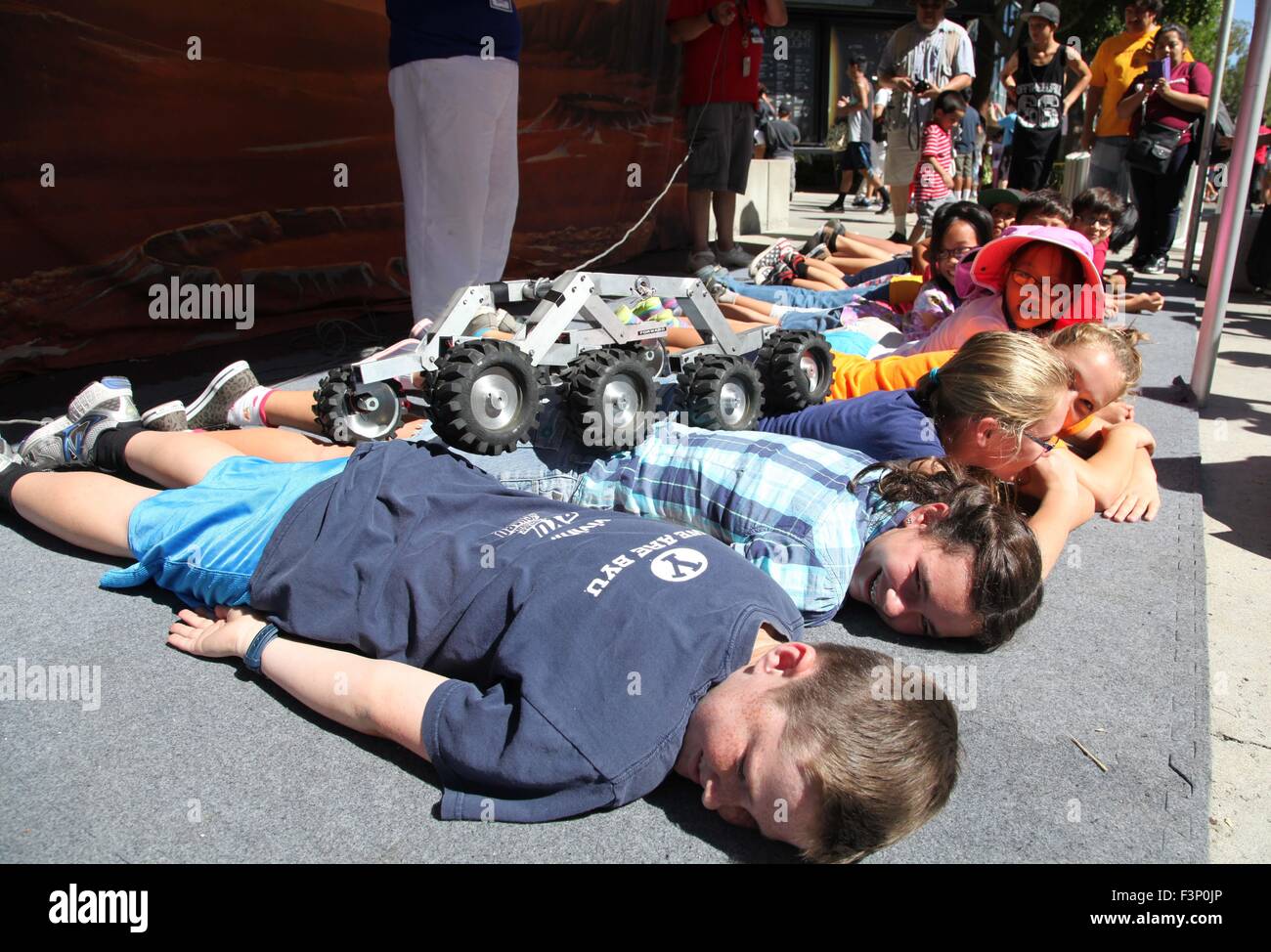 Los Angeles, USA. 10. Oktober 2015. Kinder legen Sie auf dem Boden, einen kleinen Roboter, vorbei an ihrem Körper beim JPL Open House in Los Angeles, USA, am 10. Oktober 2015 Rollen zu lassen. Zweitägigen Hausmesse des NASA Jet Propulsion Laboratory (JPL) startete am Samstag und voraussichtlich 20.000 Personen pro Tag zu gewinnen. © Xue Ying/Xinhua/Alamy Live-Nachrichten Stockfoto