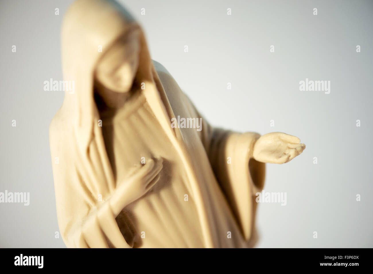 Abbildung der Jungfrau Maria mit dem Kopf verneigte sich in Demut, Nächstenliebe darstellen, wie sie ihre erweiterten Handfläche hält, hoch oben in der Nähe einer Stockfoto