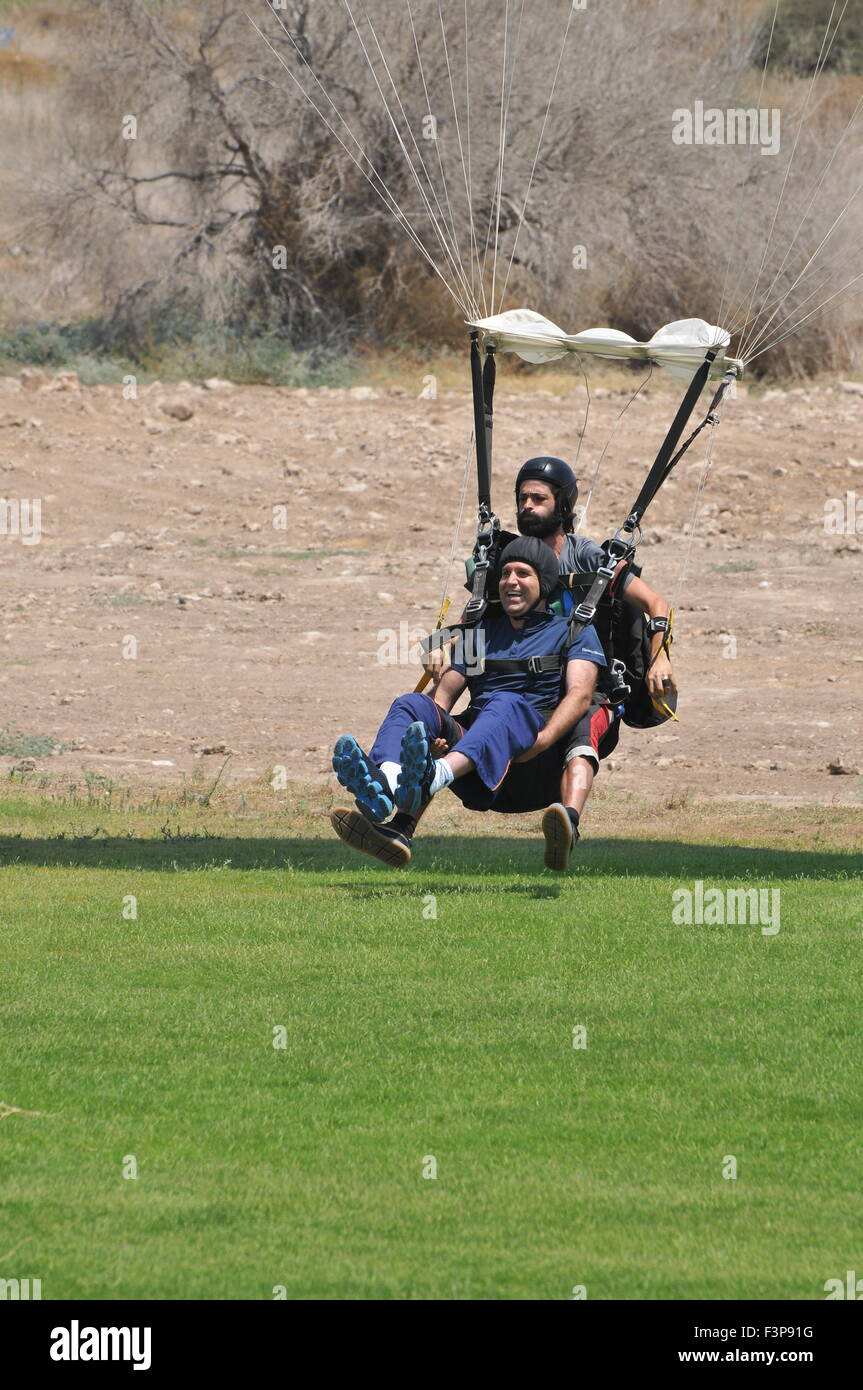 Tandem Paragliding Ausbilder und Auszubildenden zusammen gebunden, bei der Landung Stockfoto