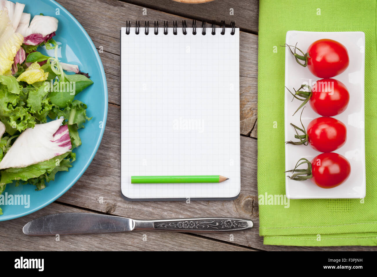 Frische gesunde Salat, Tomaten und Notizblock für textfreiraum auf Holztisch Stockfoto