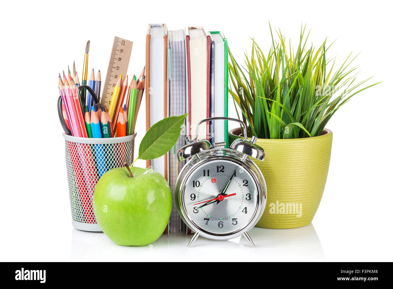 Schul- und Büromaterial. Notizblöcke, bunte Bleistifte, Blume, Wecker und Apfel. Isoliert auf weißem Hintergrund Stockfoto