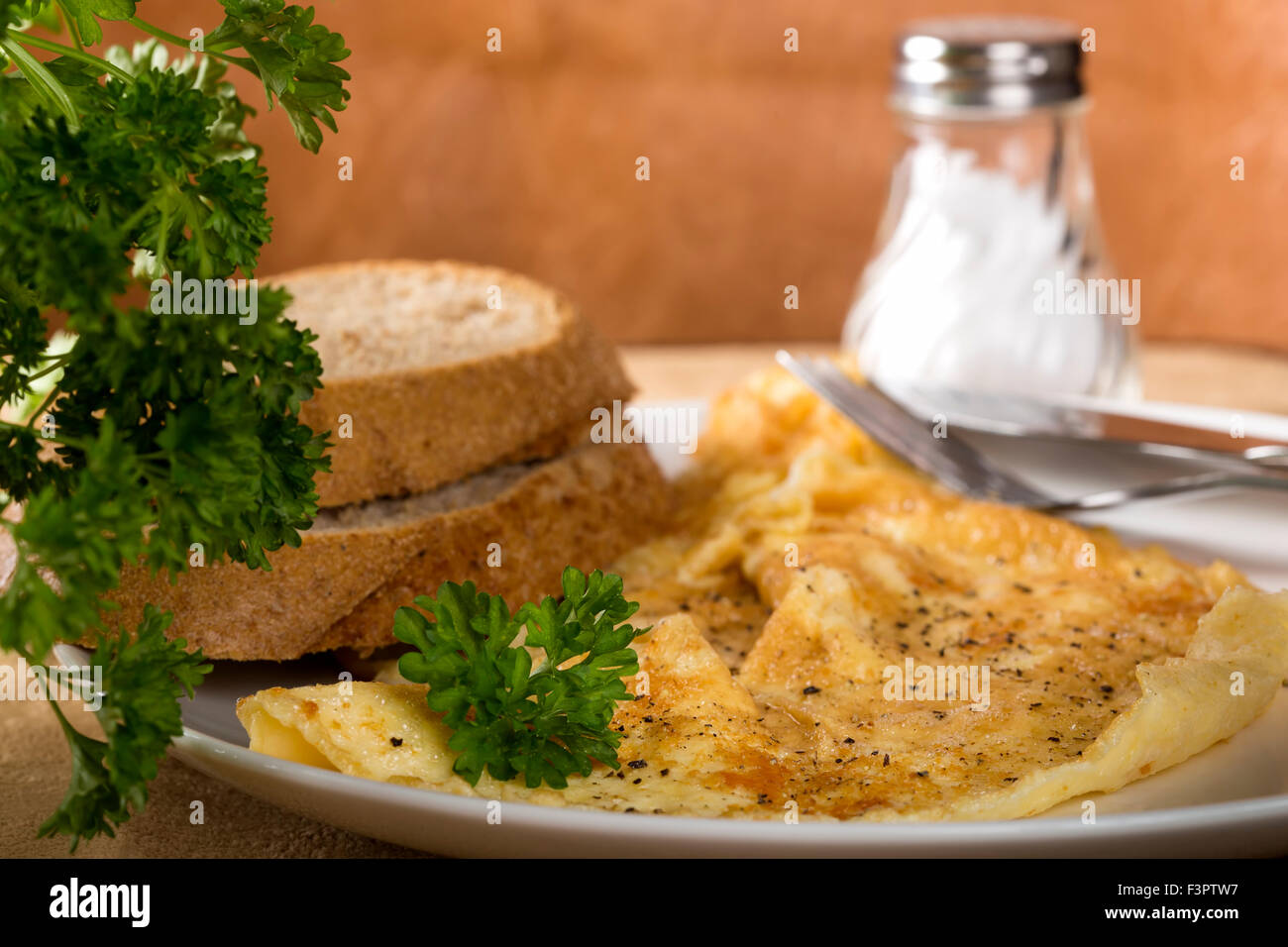 Rührei auf einer Platte mit Petersilie und Pfeffer Stockfoto