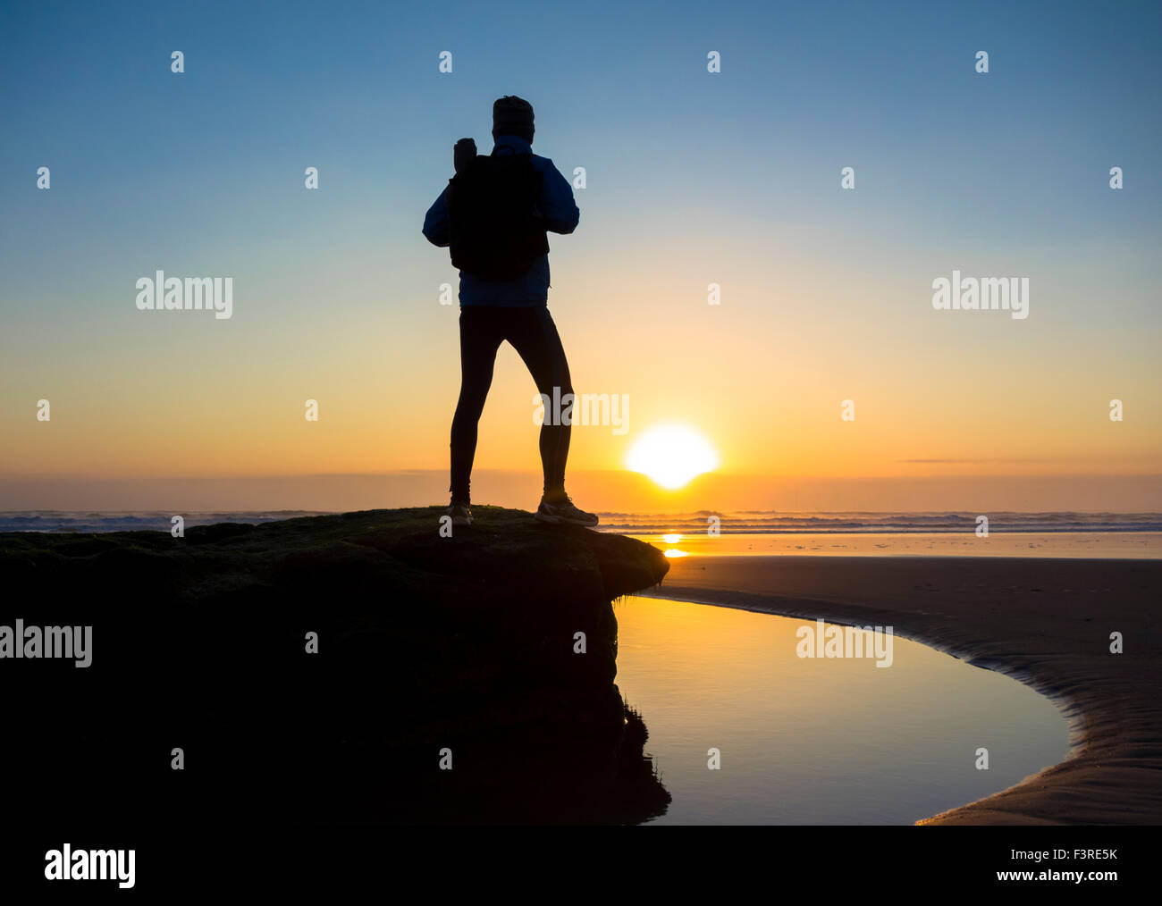 Ein Walker auf Seaton Carew Strand bei Sonnenaufgang, die 55 km lange Strecke von The England Coast Path antritt. Seaton Carew, England. UK Stockfoto