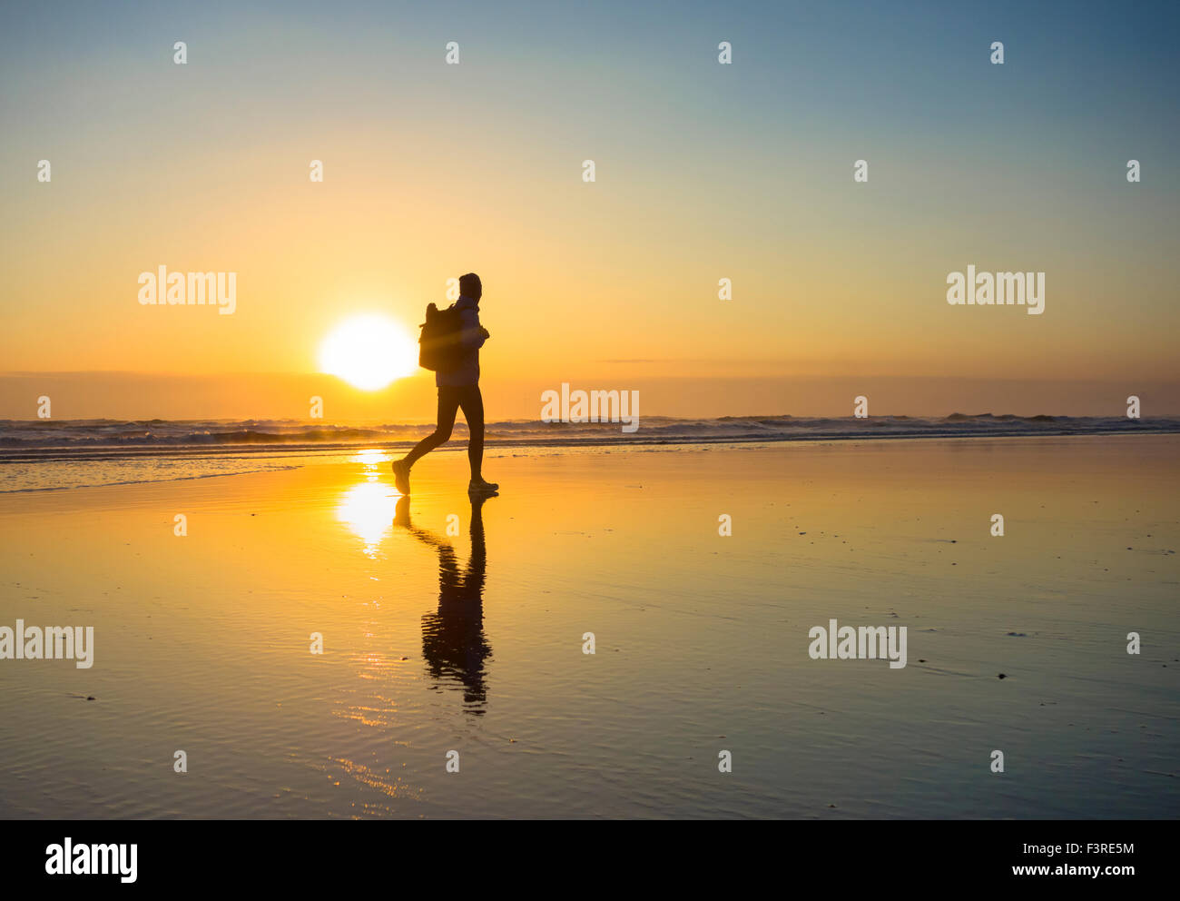 Ein Walker auf Seaton Carew Strand bei Sonnenaufgang, die 55 km lange Strecke von The England Coast Path antritt. Seaton Carew, England. UK Stockfoto