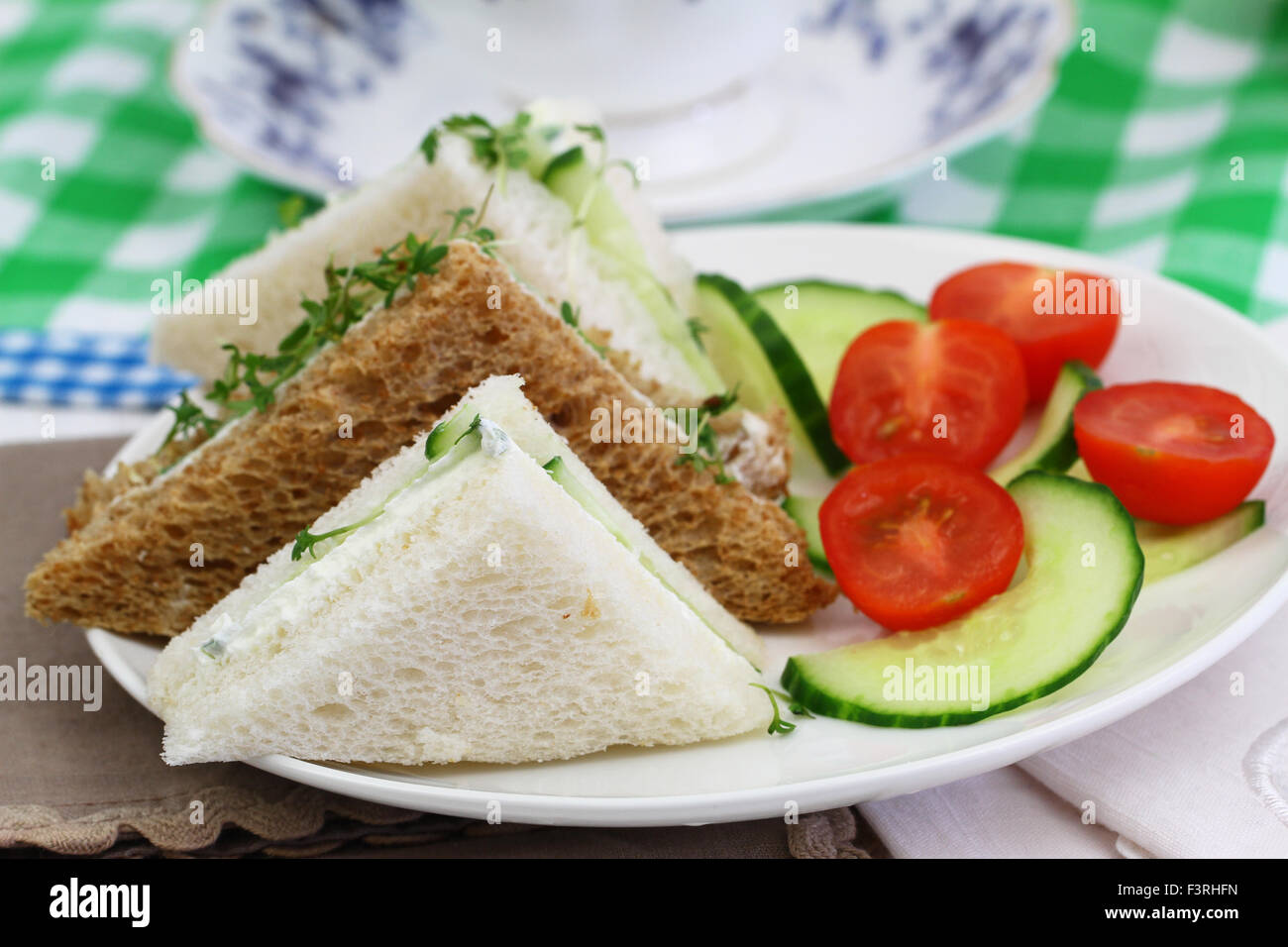 Weißer und brauner Frischkäse und Gurken-Sandwiches mit grünem Salat Stockfoto