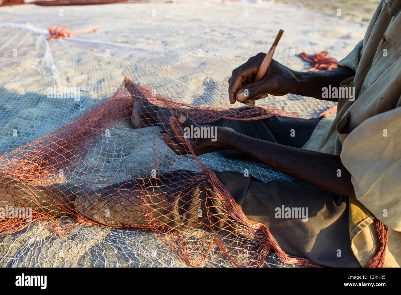 Fischer flickt ein Netz auf am Ufer des Lake Malawi, Malawi, Afrika Stockfoto