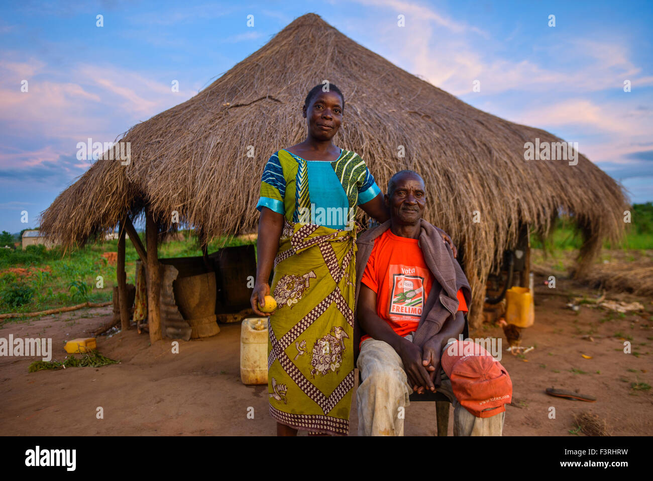 Paar vor einer strohgedeckten Hütte, Mosambik, Afrika Stockfoto