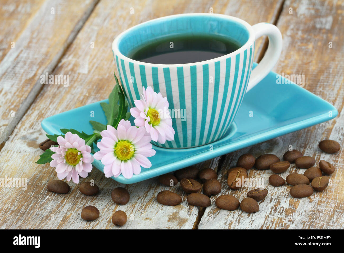 Tasse Kaffee und rosa Gänseblümchen Blumen auf rustikalen Holzoberfläche Stockfoto