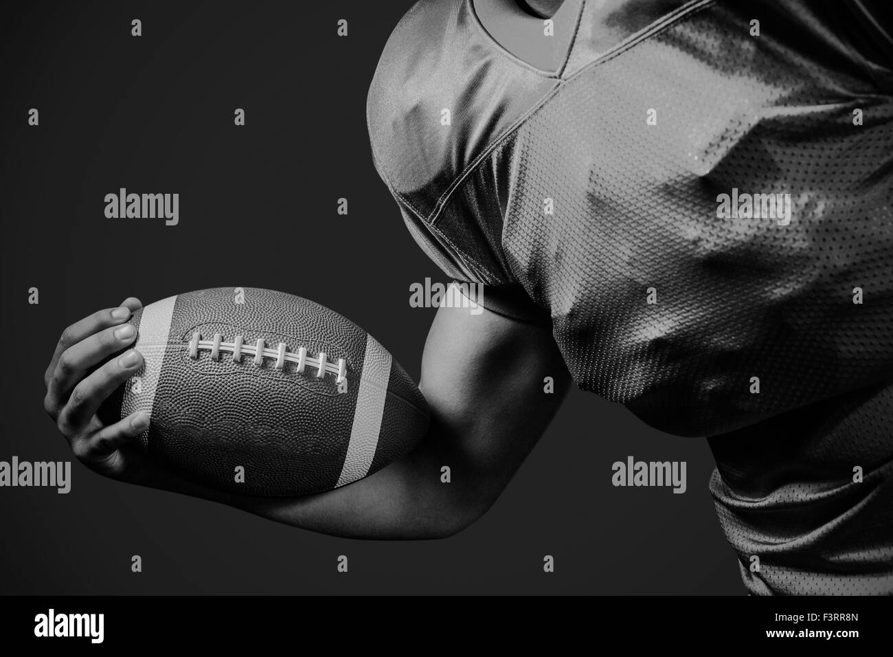 Zusammengesetztes Bild beschnitten american Footballspieler mit ball Stockfoto