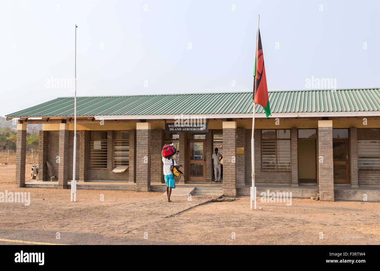 Luftverkehr und Reisen, fliegen in Malawi: Porter mit Gepäck, Likoma Insel Flugplatz Terminalgebäude, Lake Malawi, Malawi, Süd-Ost-Afrika Stockfoto