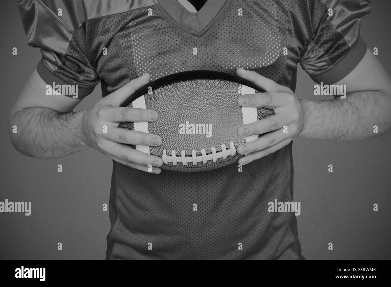 Zusammengesetztes Bild des american Footballspieler mit einem ball Stockfoto