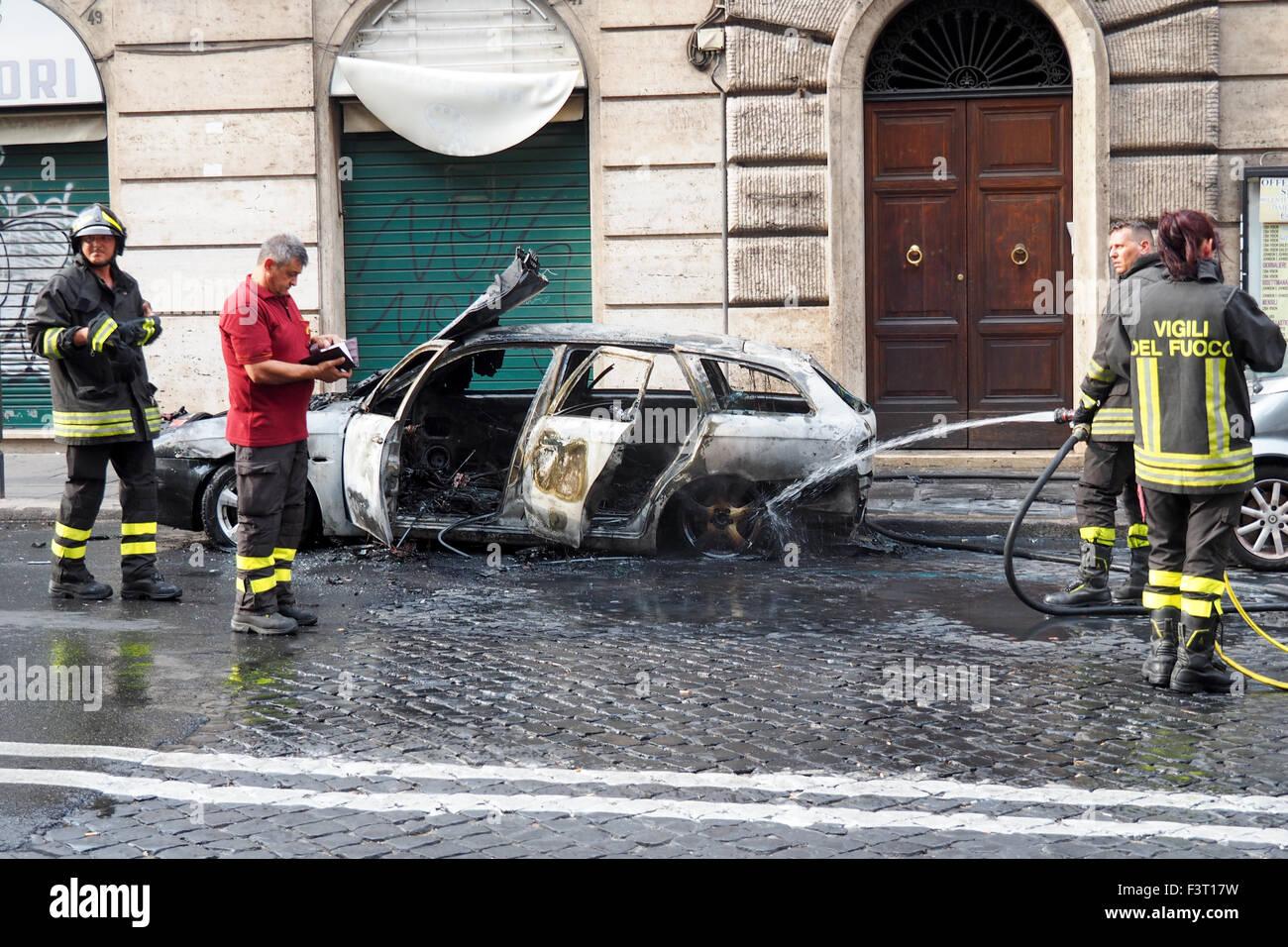 Feuerwehr Schlauch einen verbrannten Fahrzeug. Stockfoto
