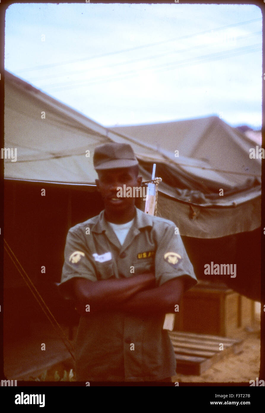 Ein schwarzer steht amerikanischer Soldat der United States Army neben einem Zelt am Nocken Rahn Bucht, eine Position des 1. logistische Befehls während des Vietnam-Krieges. Stockfoto