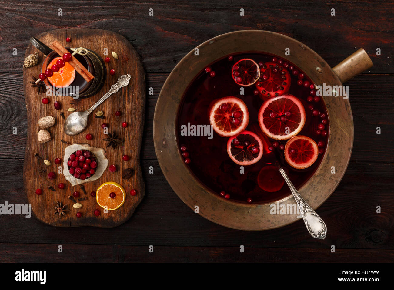Cranberry Zitrus Punsch oder Glühwein mit Zutaten über dunklen Holztisch. Stockfoto