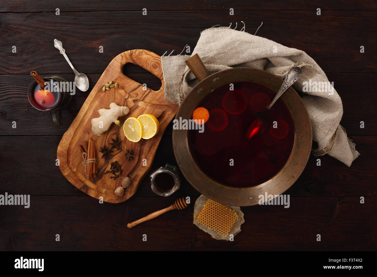 Honig Ingwer Zitrone Glühwein Wein oder Punsch in Messing Schale über dunklen Holztisch. Ansicht von oben Stockfoto