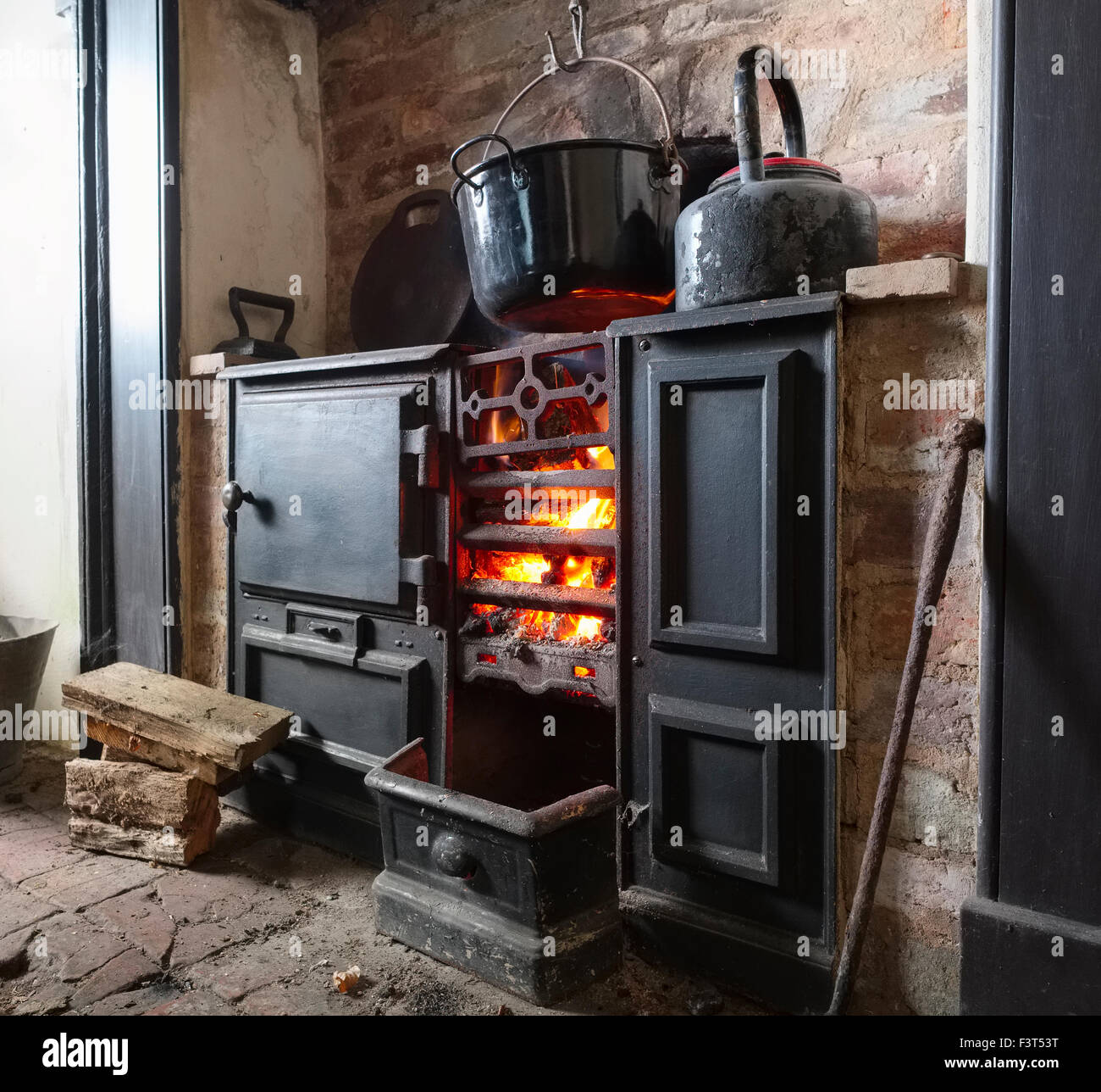 Ein Kaminfeuer in einer Gusseisen-Reihe in einer restaurierten Bergarbeiter Hütte am Blakemoregate, in der Nähe von Snailbeach, Shropshire. Stockfoto