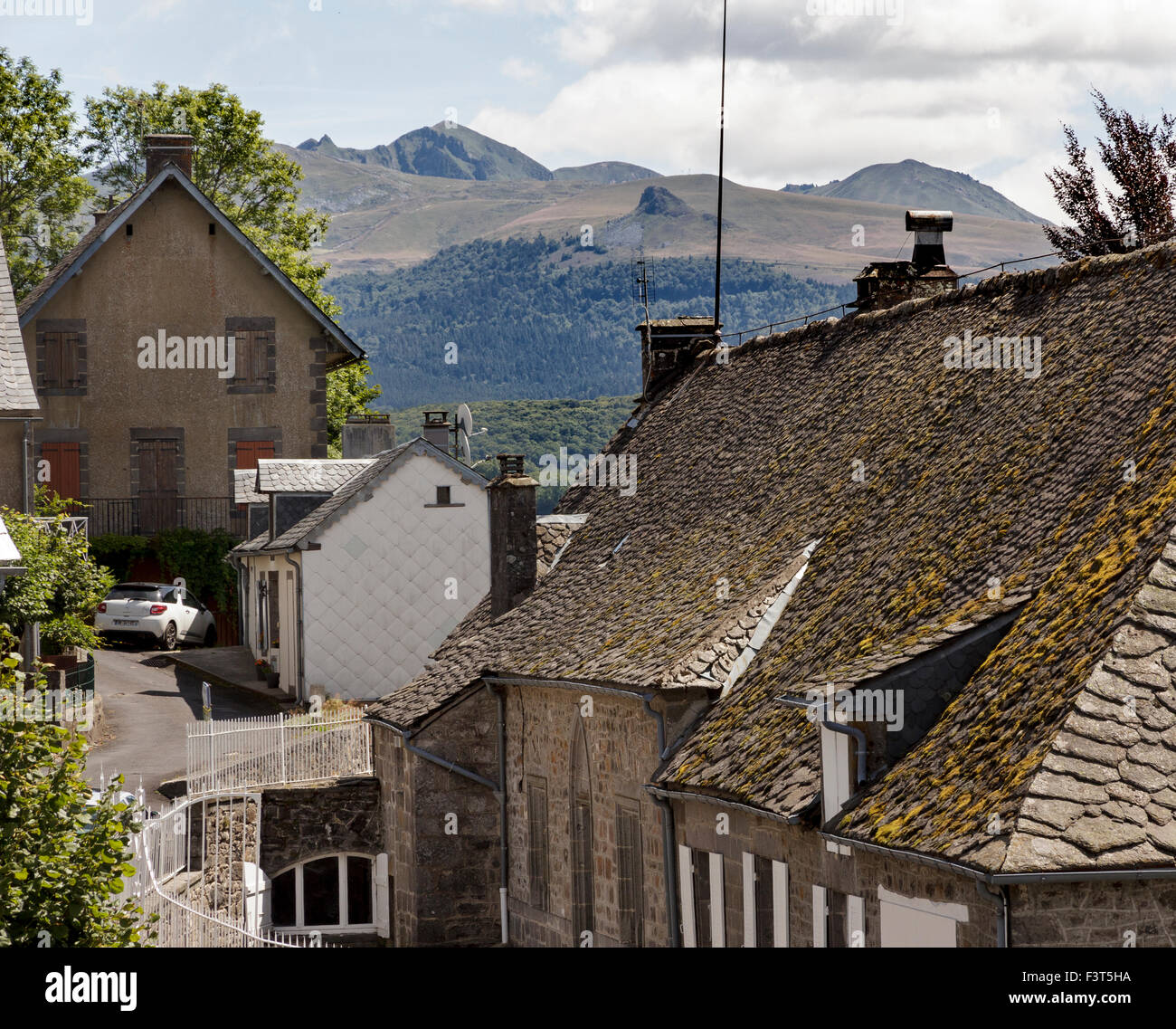 Die Stadt von La Tour d ' Auvergne mit Puy de Sancy und ein weiteres erloschener Vulkan im Hintergrund Stockfoto