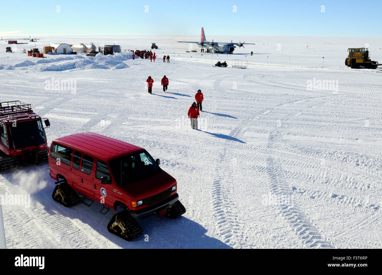 Kettenfahrzeug, Menschen, Gebäude und Flugzeuge am Südpol Stockfoto