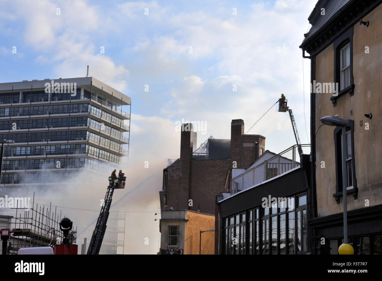 Bristol, UK. 12. Oktober 2015. Ein Großbrand begann ca. 13:00 h im University of Bristol Studentenwohnheim, 33 Colston Straße, Bristol, England, 12. Oktober 2015, von Avon Feuer & Rettungsdienste mit zwei Plattenspieler Leiter Feuerwehrfahrzeuge und mehr als vier weitere Module in Angriff genommen. Die Lage ist zwischen der Colston Hall und Griffin Pub in der Nähe der Kreuzung der Colston und Trenchard Street und diese Straßen für Fahrzeuge und Fußgänger geschlossen worden. Das Feuer hat die gesamte Länge des Daches und obersten Etage vollständig zerstört. Bildnachweis: Charles Stirling/Alamy Live-Nachrichten Stockfoto