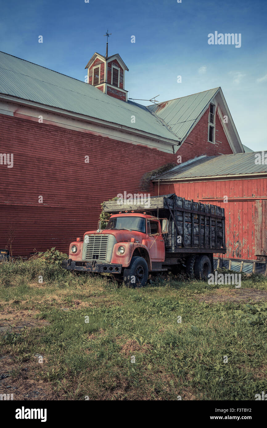 Einem alten roten Bauernhof LKW vor einer alten roten Scheune in Vermont. Stockfoto