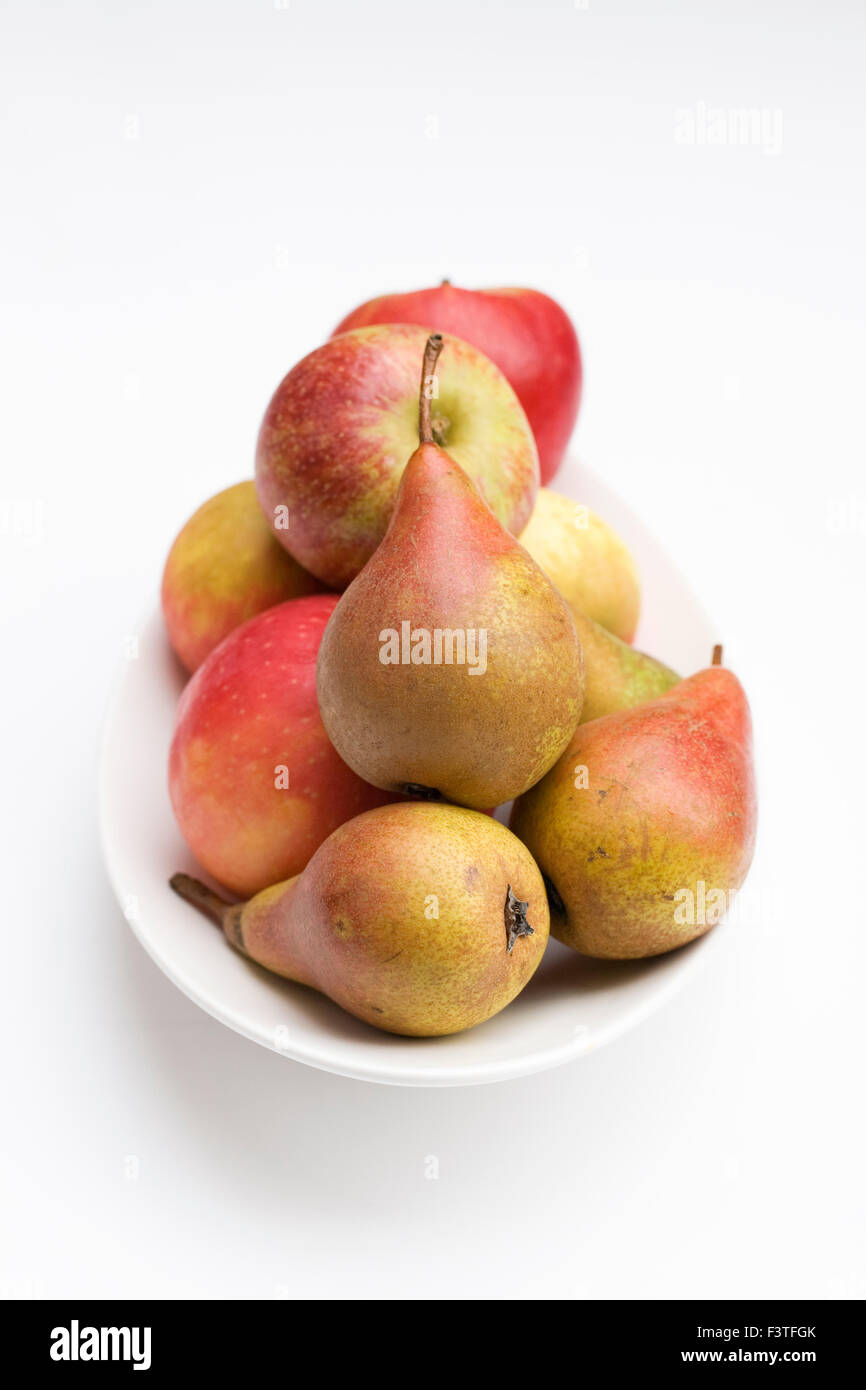 Äpfel und Birnen in einer weißen Schale. Stockfoto