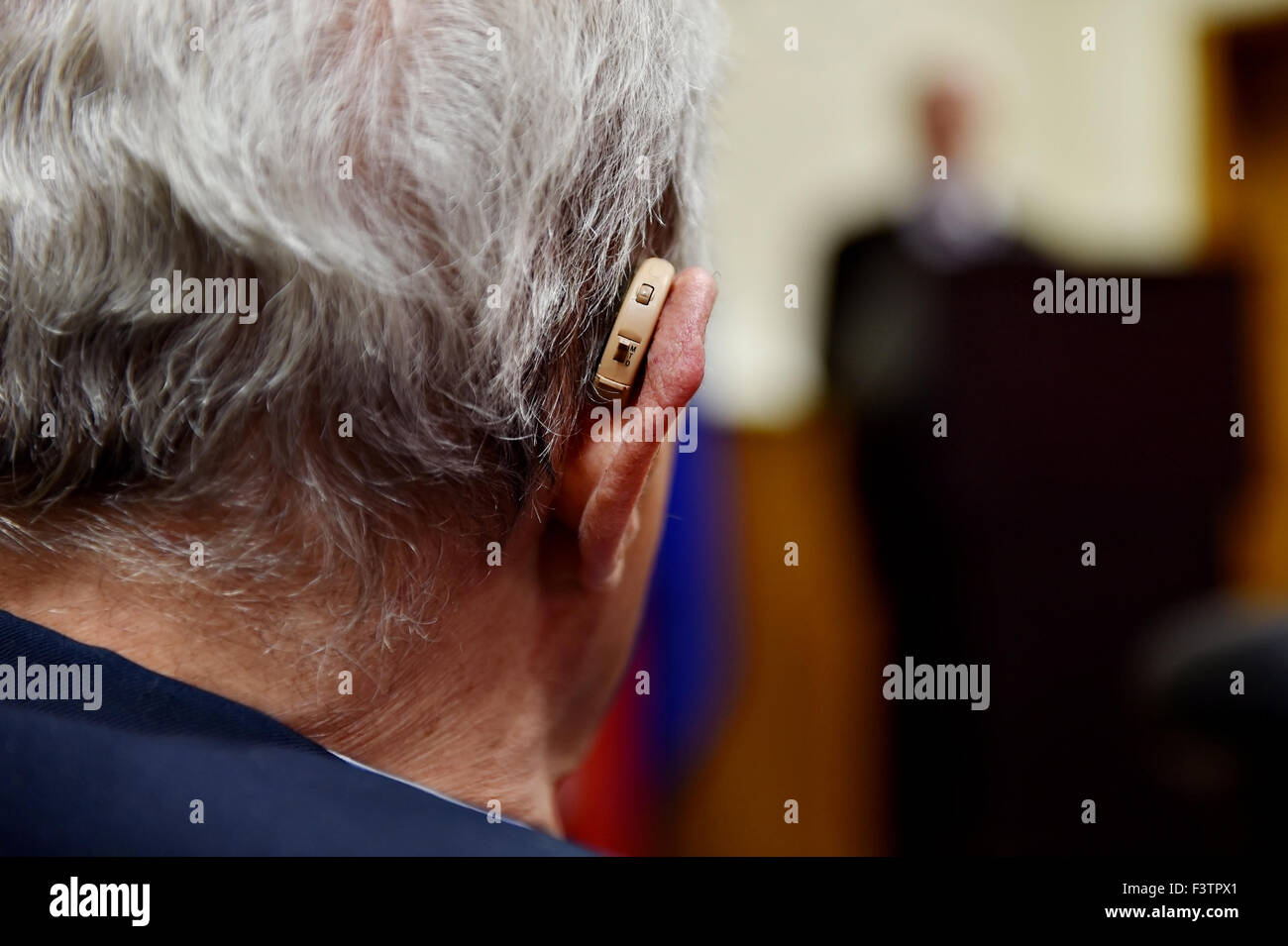Detail mit einem Hörgerät Gerät verwendet während der Konferenz von alten Mann erschossen Stockfoto