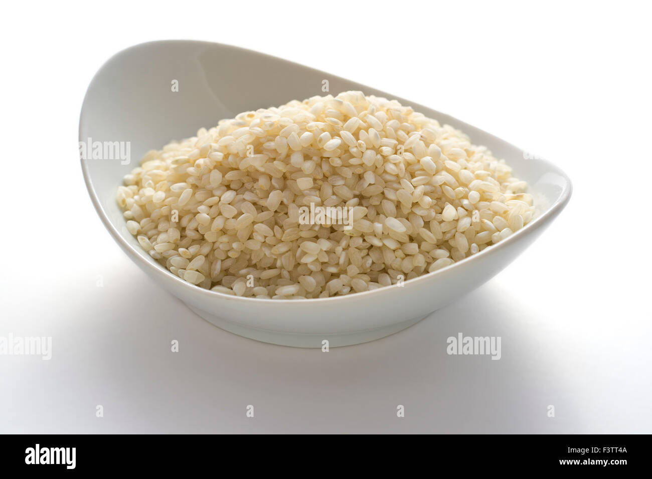 Schüssel voller Reis auf weißem Hintergrund Stockfoto