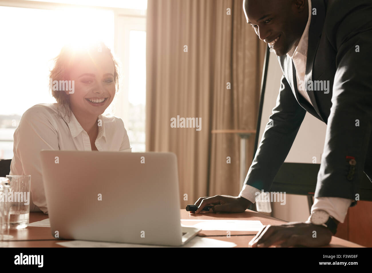 Porträt von glücklich Jungunternehmen Team zusammenarbeiten auf Laptop. Kaufmann und Kauffrau im Konferenzraum treffen. Stockfoto