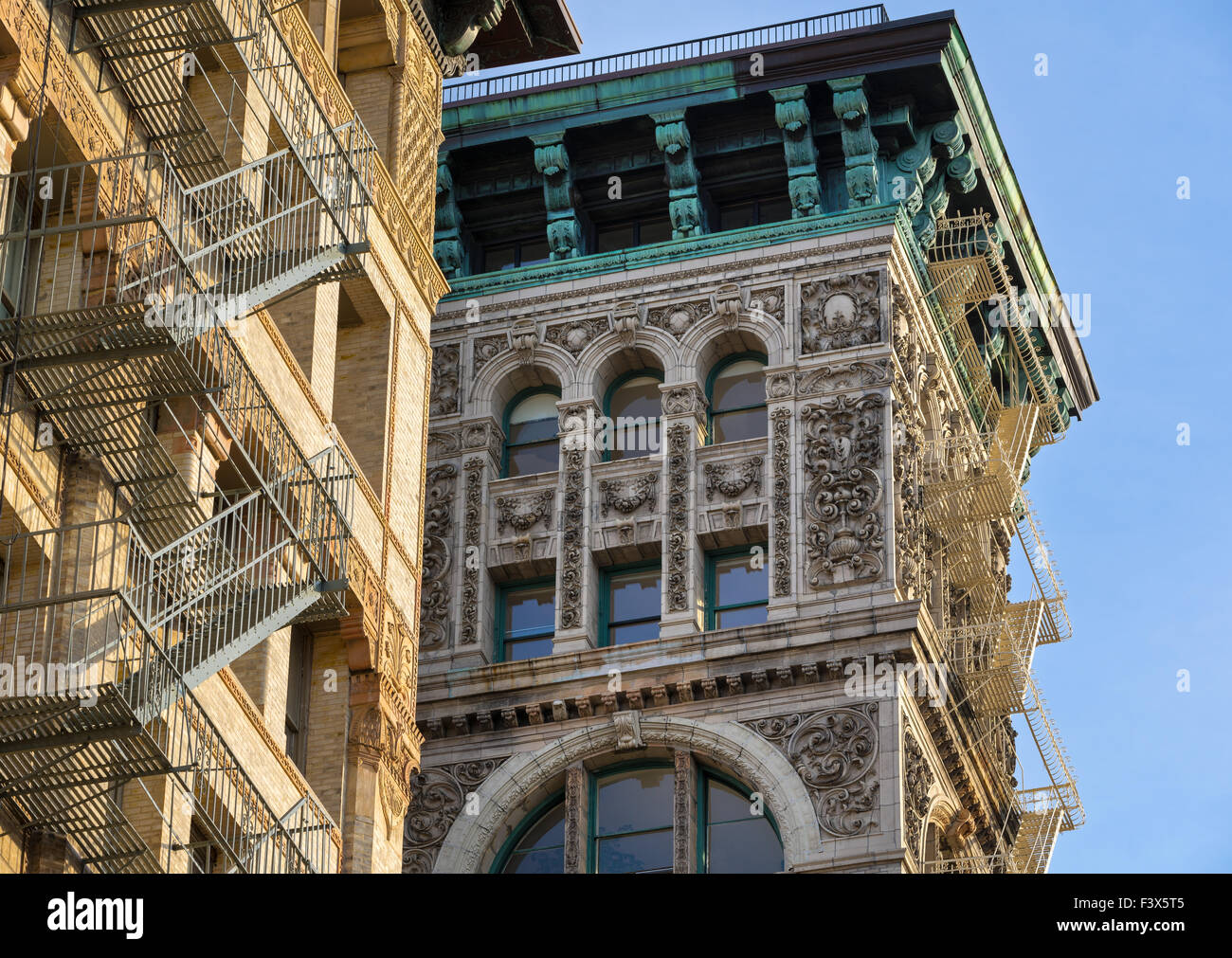 Aufbau der Fassade mit Terrakotta-Ornament, Kupfer Gesims und Feuerleitern in Soho, Broome Street, Manhattan, New York City, USA Stockfoto
