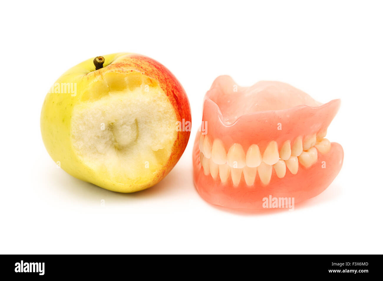 Prothese und angebissene Apfel Stockfoto