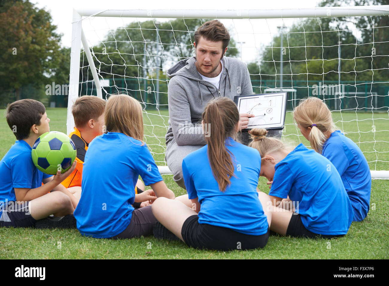 Trainer geben Teamsitzung zur Grundschule Fußballmannschaft Stockfoto