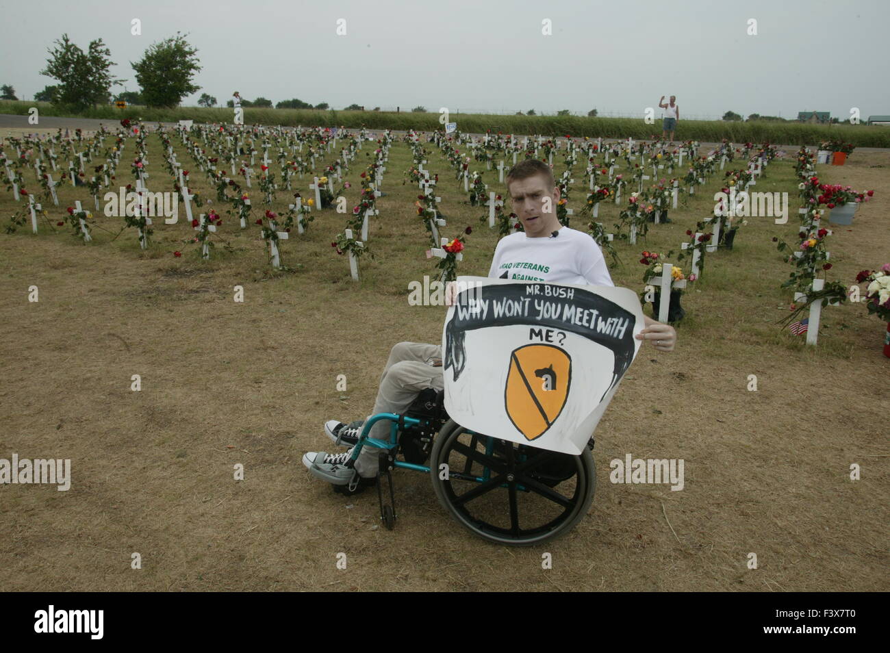 Tomas Young, der am selben Tag als Casey Sheehan verletzt wurde getötet wurde, sagt, dass er ein Treffen mit Bush über Stammzellforschung haben möchte. Young war wie gelähmt, als er erschossen wurde, während der Fahrt in einen LKW. Er hält ein Schild in seinem Rollstuhl sitzend während Antikriegsproteste in Crawford Texas. Stockfoto