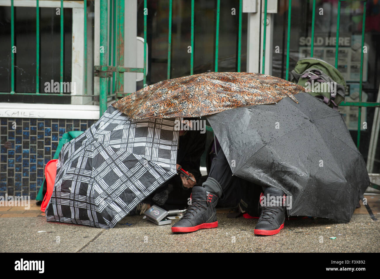 Menschen unter einem Baldachin von Regenschirmen versuchen, bleiben trocken, Hastings Street, Vancouver, Britisch-Kolumbien Stockfoto