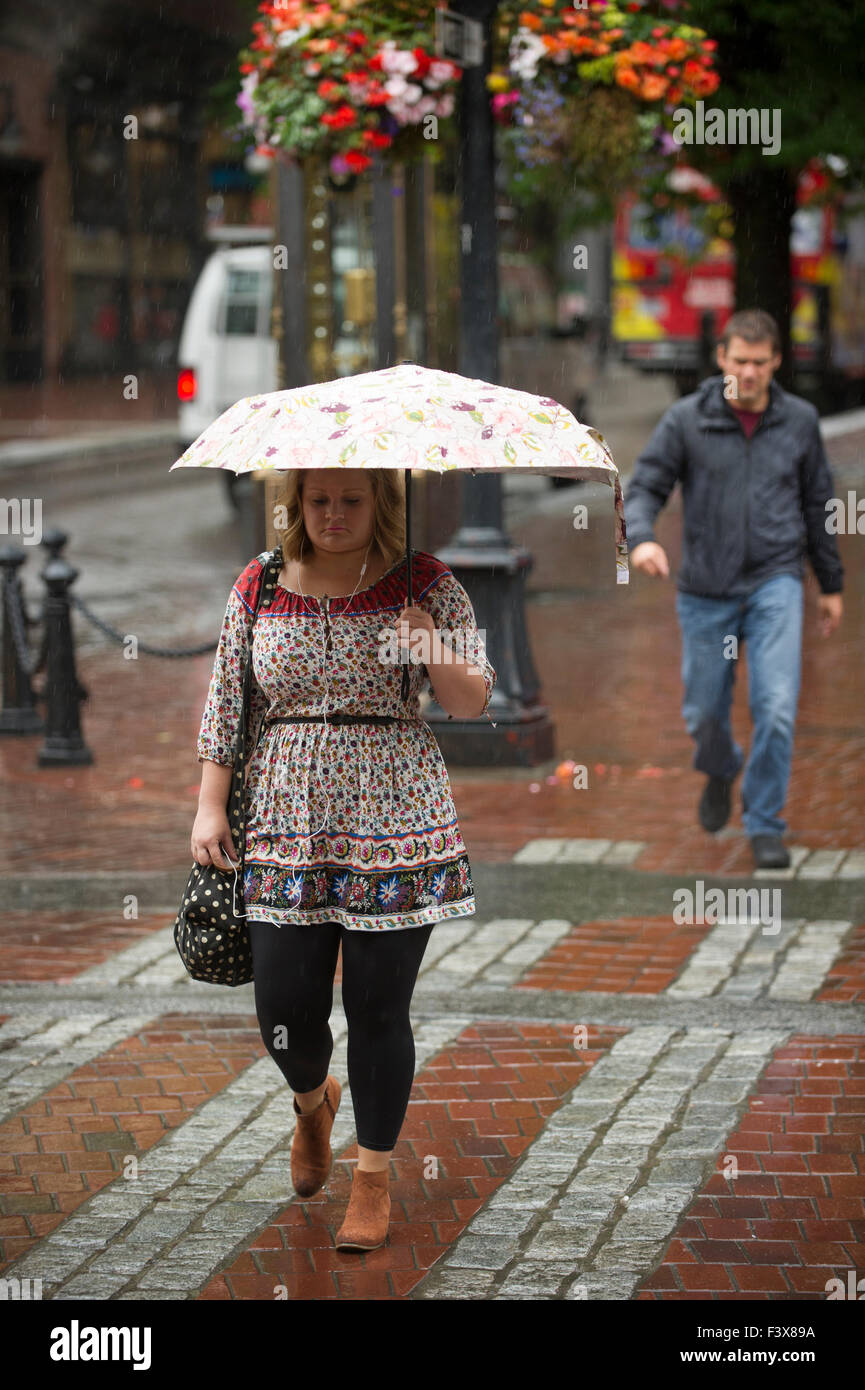 Frau zu Fuß in den Regen halten einen Regenschirm, Vancouver. Stockfoto