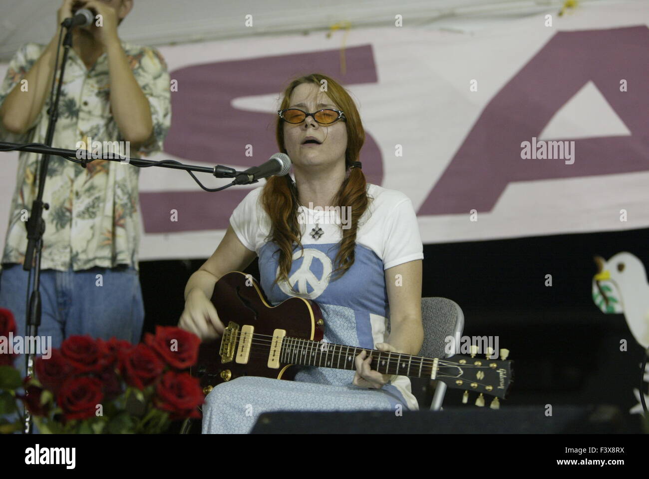 Eine Friedensaktivistin singt Anti-Kriegs-Liedern bei den Protest gegen Bush in Crawford, Texas. Stockfoto