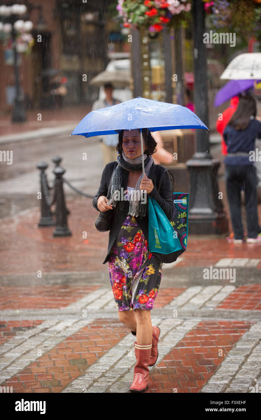 Frau zu Fuß in den Regen halten einen Regenschirm, Vancouver. Stockfoto