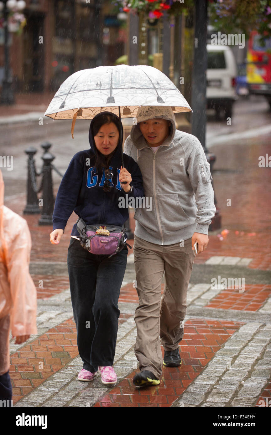 Paar hält einen Regenschirm zu Fuß in den Regen, Vancouver. Stockfoto