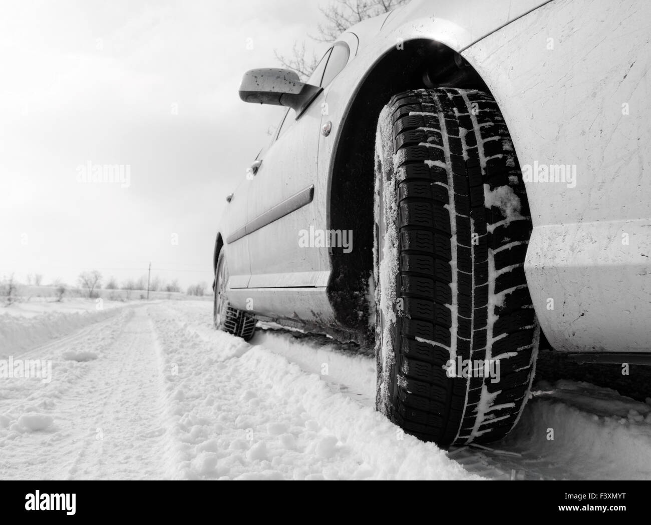 Nahaufnahme von einem Pkw-Reifen auf einer verschneiten Straße Stockfoto