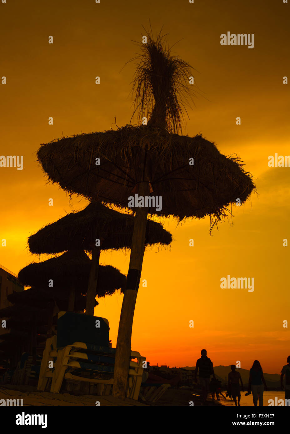 Stroh Sonnenschirme bei Sonnenuntergang Stockfoto