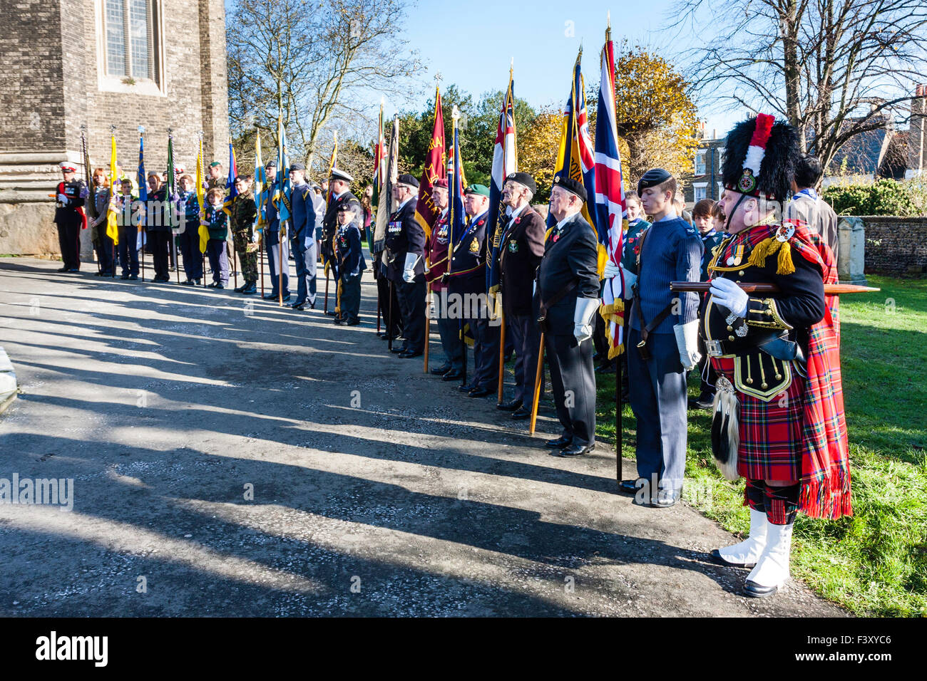 Erinnerung Sonntag, England. Feldwebel, schottische Highlander, bei der die Zeile der Ex-Soldaten holding Banner stehen zur Aufmerksamkeit mit langen Schatten. Stockfoto