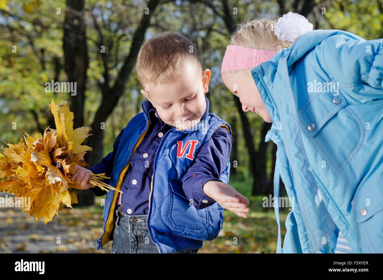 Kleinkinder mit Herbstlaub Stockfoto