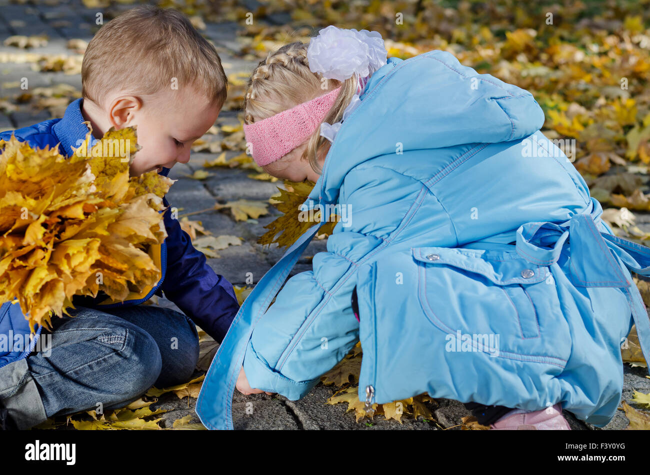 Kinder spielen im Herbstlaub Stockfoto