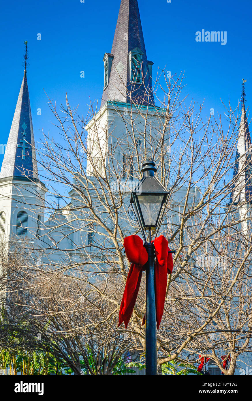 Großer roter samt Urlaub Zierschleife um antike Lampen-Pfosten mit St. Louis Cathedral, Jackson Square, New Orleans LA gebunden Stockfoto