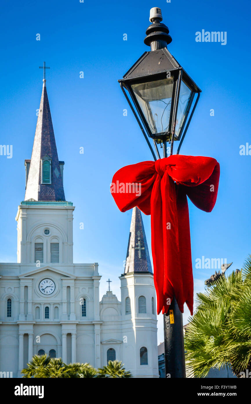 Riesige rote samt Urlaub dekorative Bögen um antike Lampe gebunden Beiträge mit Jackson Square, St. Louis Cathedral, New Orleans LA Stockfoto