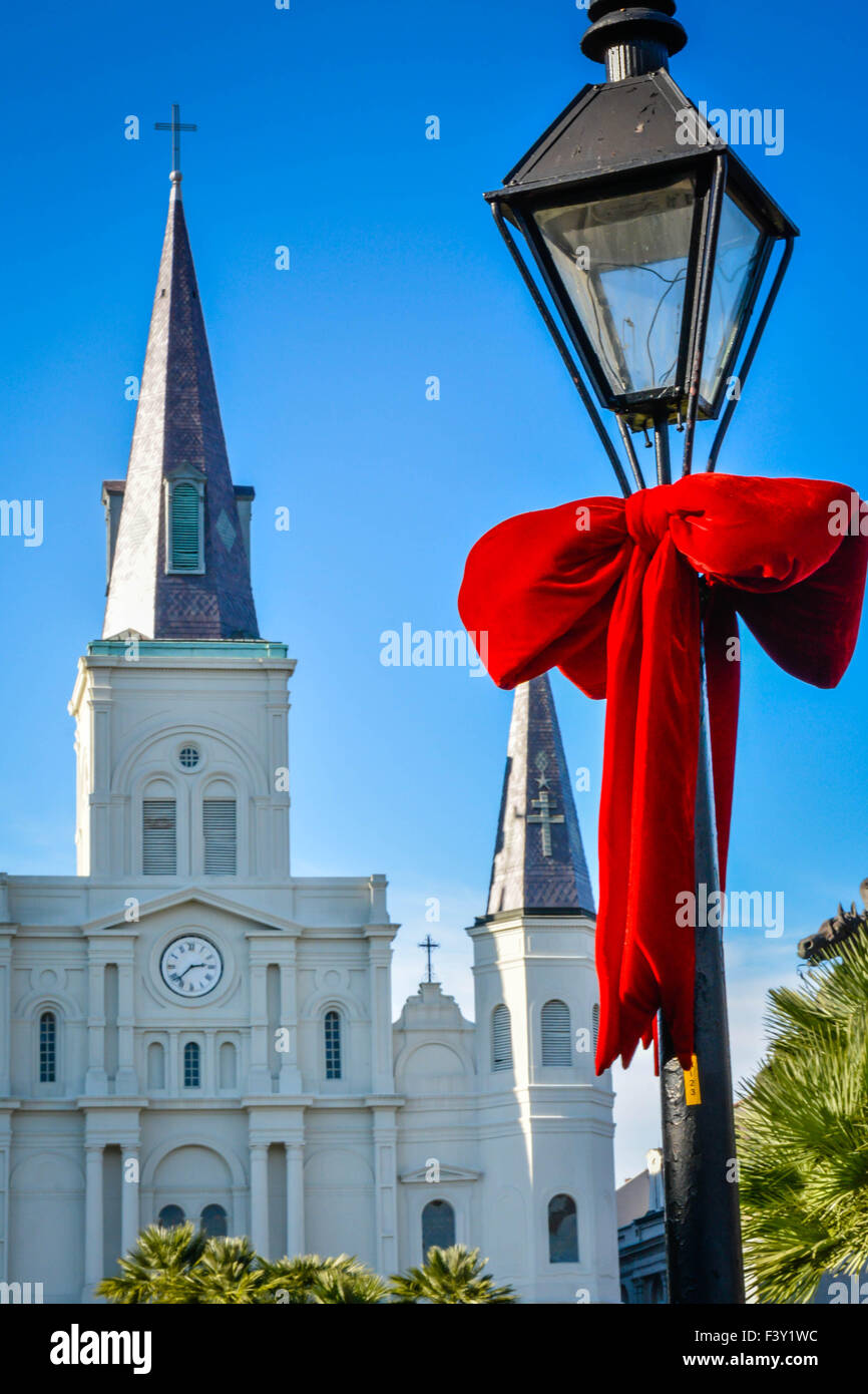 Riesige rote samt Urlaub dekorative Bögen um antike Lampe gebunden Beiträge mit Jackson Square, St. Louis Cathedral, New Orleans LA Stockfoto