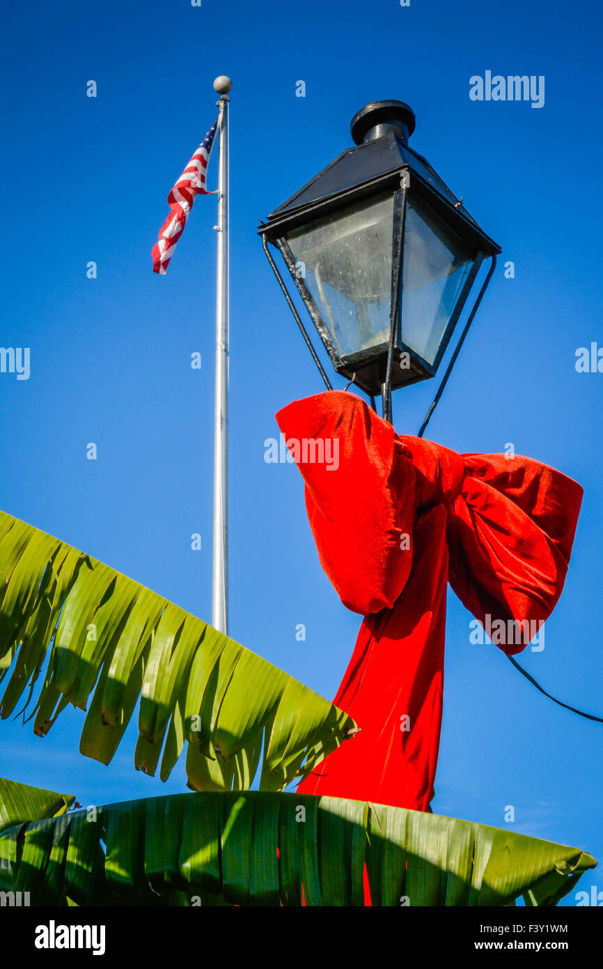 Großer roter samt Urlaub Zierschleife um antike Lampen-Pfosten mit USA Flagge & Palme Wedel, Jackson Square, New Orleans LA gebunden Stockfoto