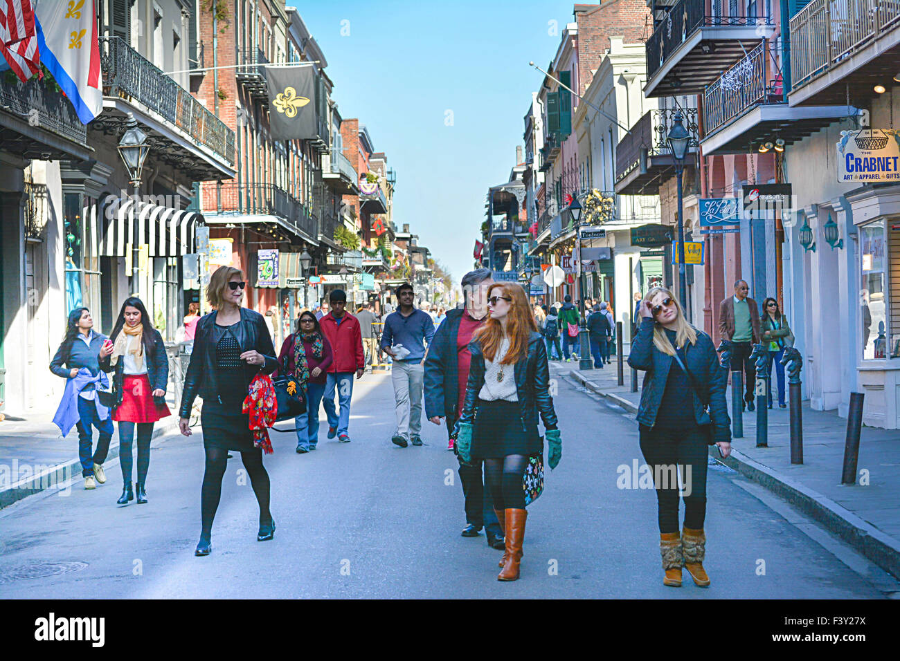 Frech und stilvolle Frauen gehen vor einer Gruppe von Menschen, die ein Spaziergang in der Mitte der Bourbon Street in New Orleans, LA Stockfoto